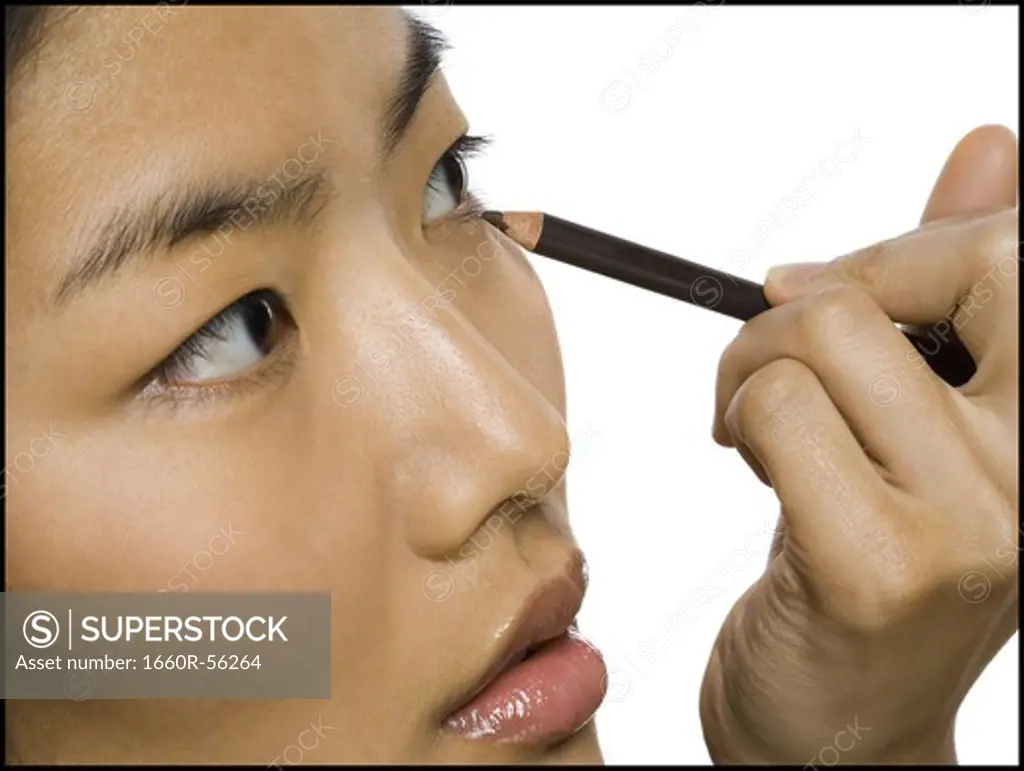 Closeup of woman applying eyeliner
