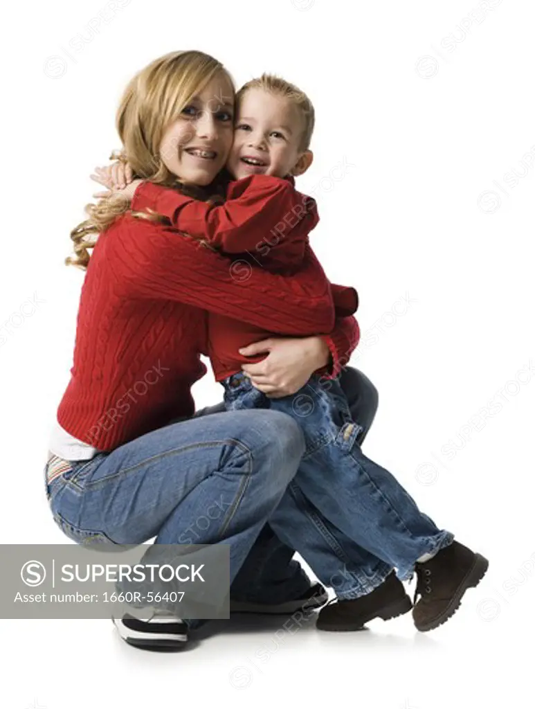 Teenage girl hugging young boy