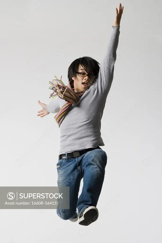 Man with eyeglasses leaping with arm up and closed fists