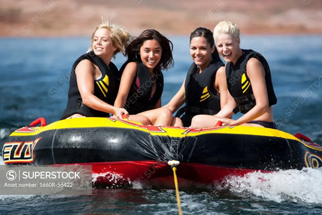 Four women on inner tube wearing life jackets
