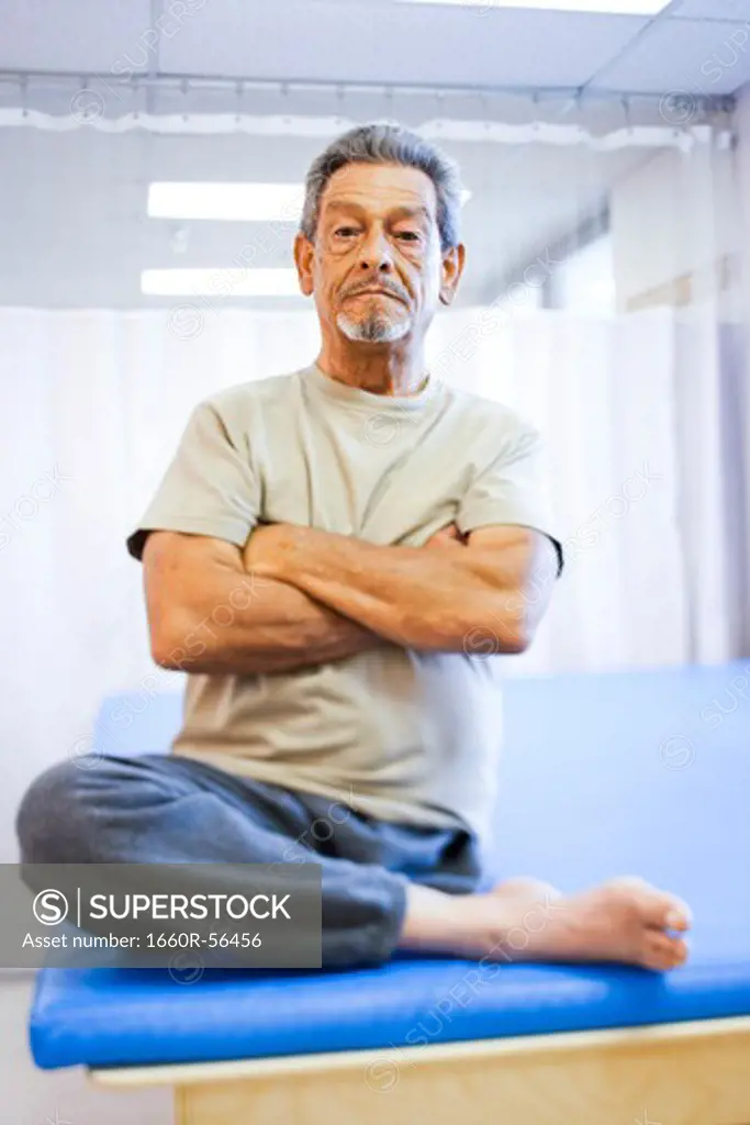 Man with one leg sitting with arms crossed smiling