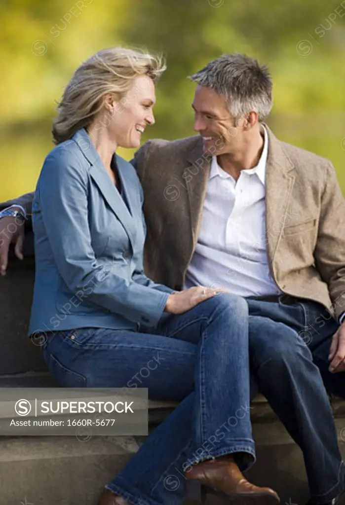 Couple sitting together in a park and laughing