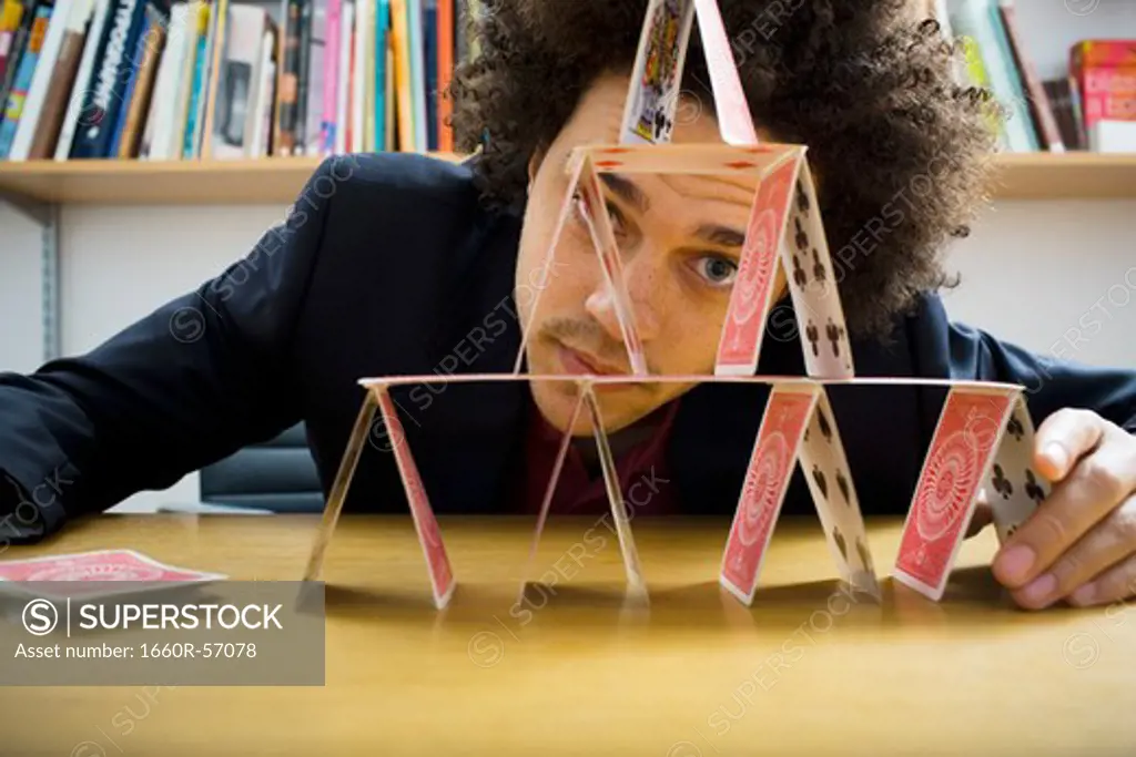 Man making a pyramid out of playing cards