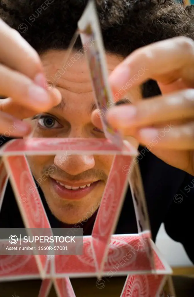 Man making a pyramid out of playing cards