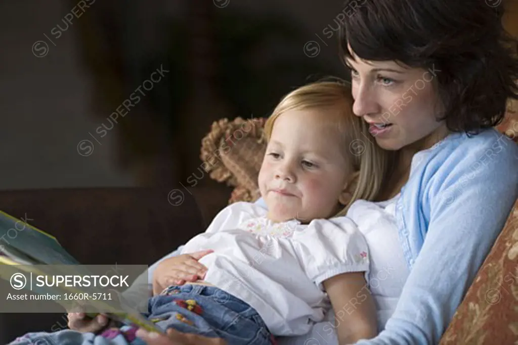 Close-up of a mother reading to her daughter
