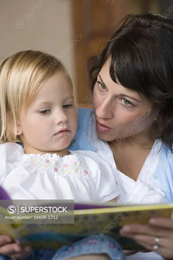 Close-up of a mother reading to her daughter