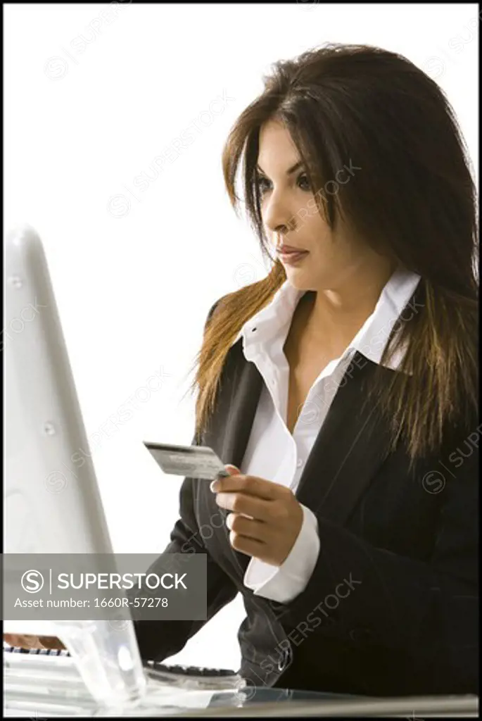 Woman using her credit  card on her computer