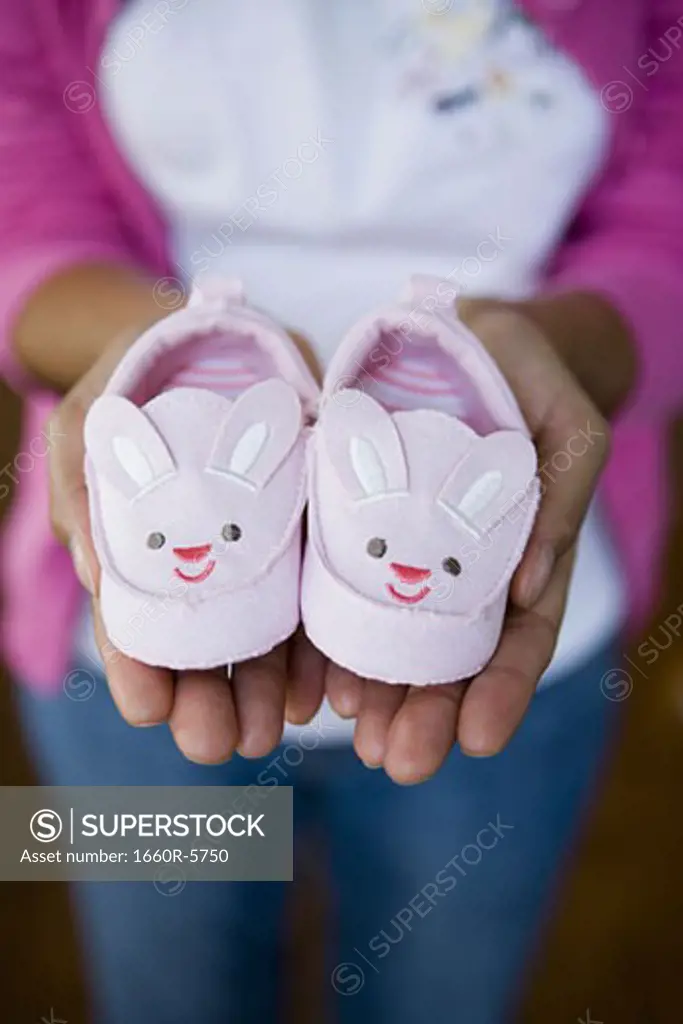 High angle view of a person holding baby shoes