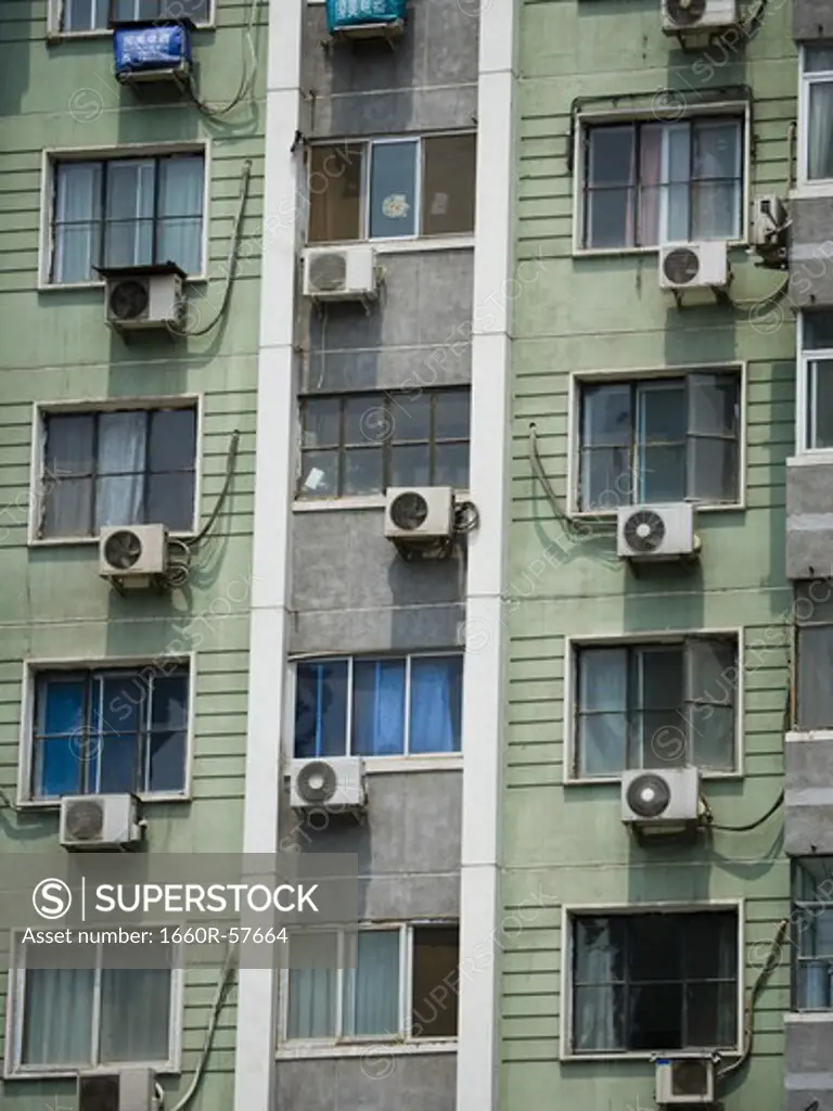 Detailed view of windows in apartment building with air conditioning units