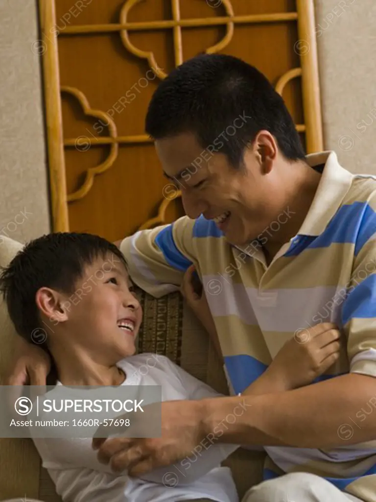 Father and son tickling each other