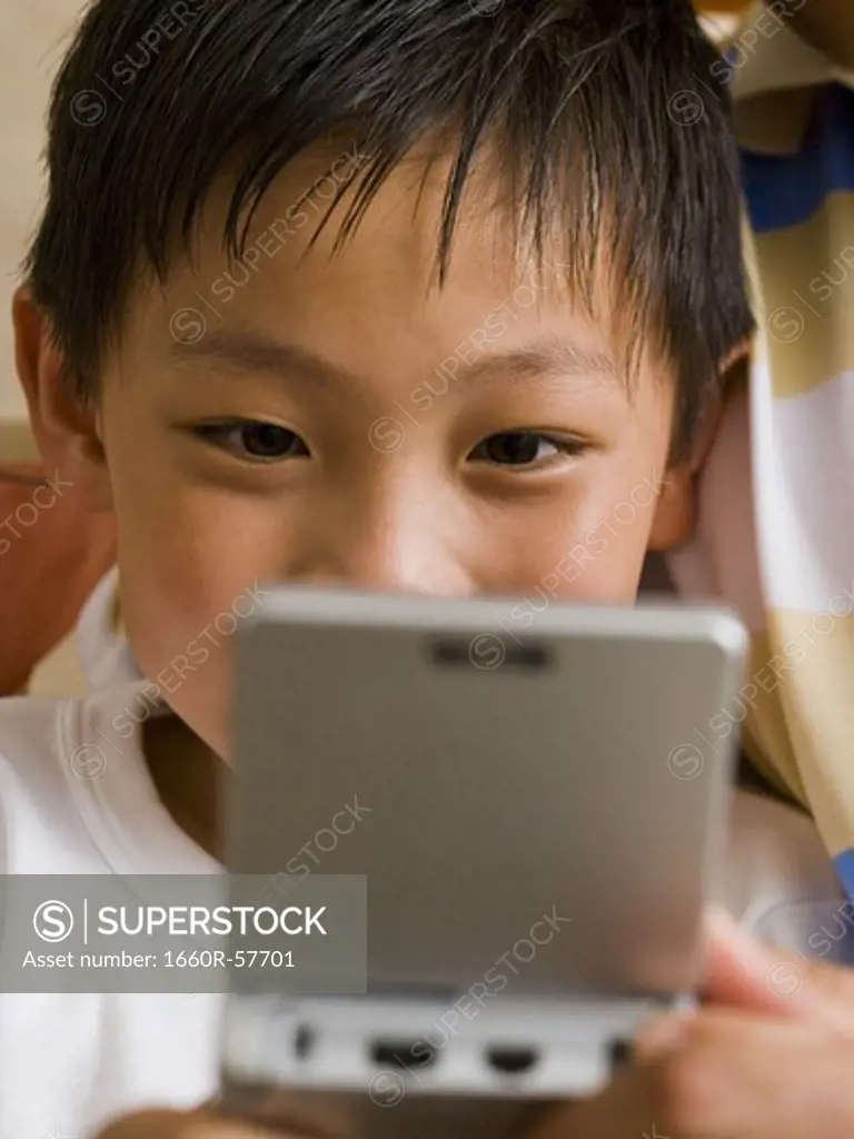 Closeup of boy with handheld electronic device