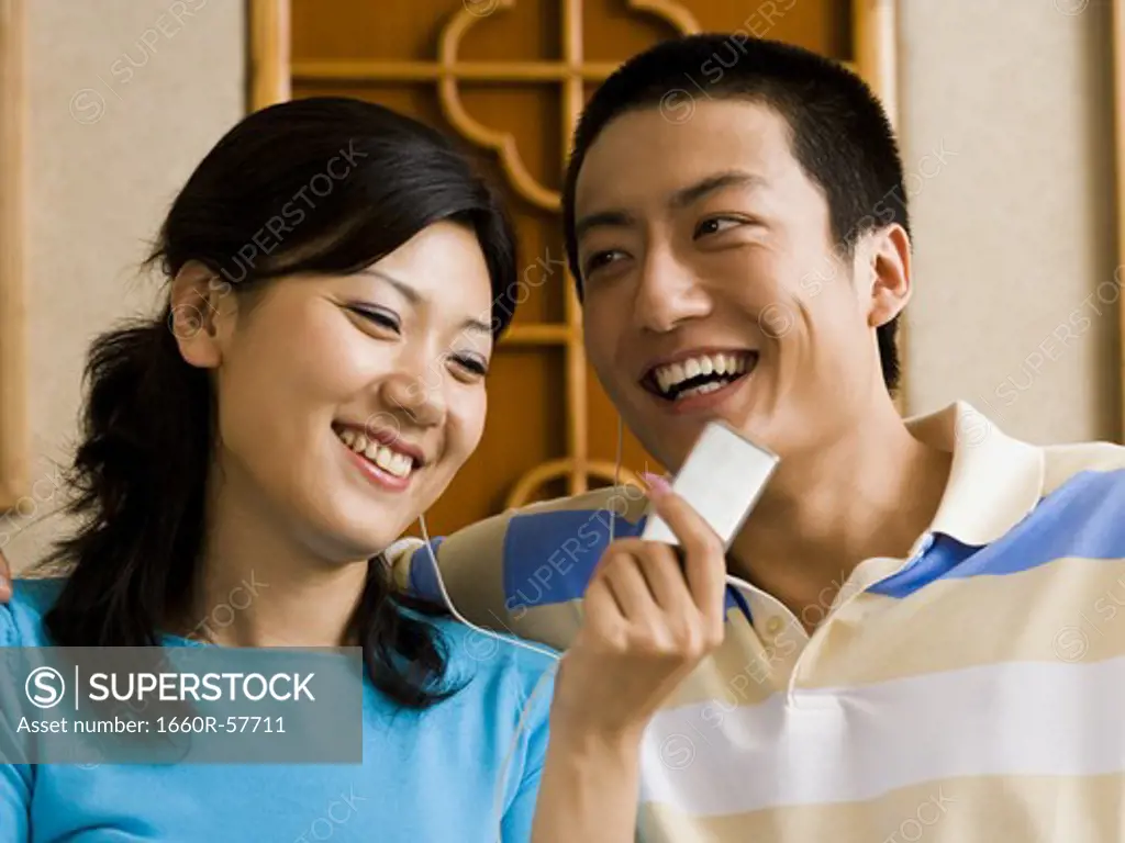 Couple listening to MP3 player smiling