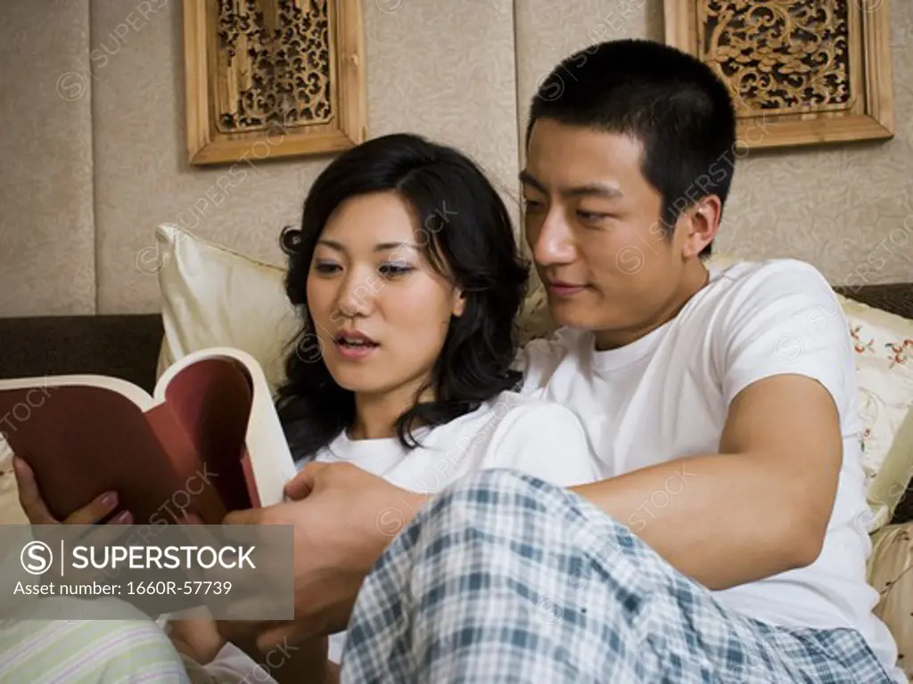 Couple in bed snuggling and reading