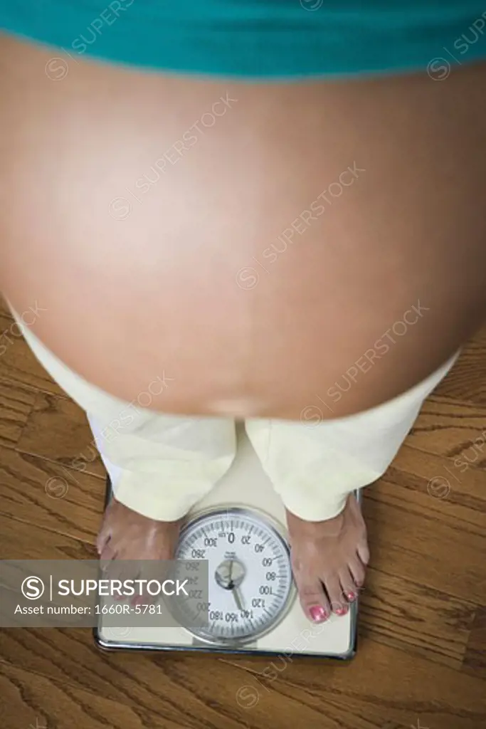 High angle view of a pregnant woman standing on scale