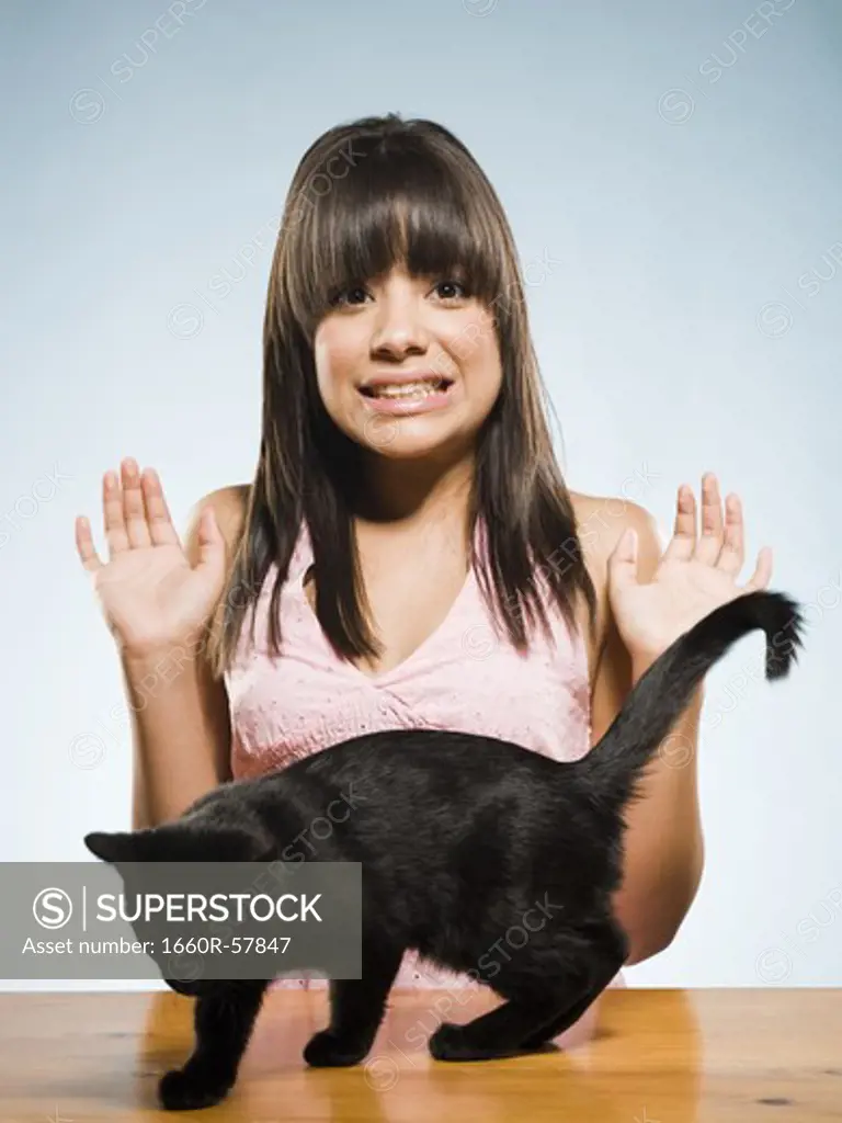 Scared woman with black kitten