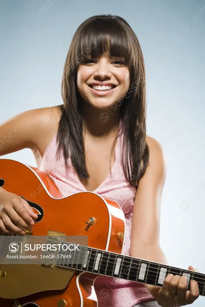 Woman playing guitar smiling