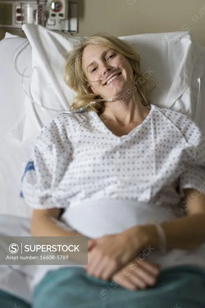 High angle view of a smiling female patient in bed