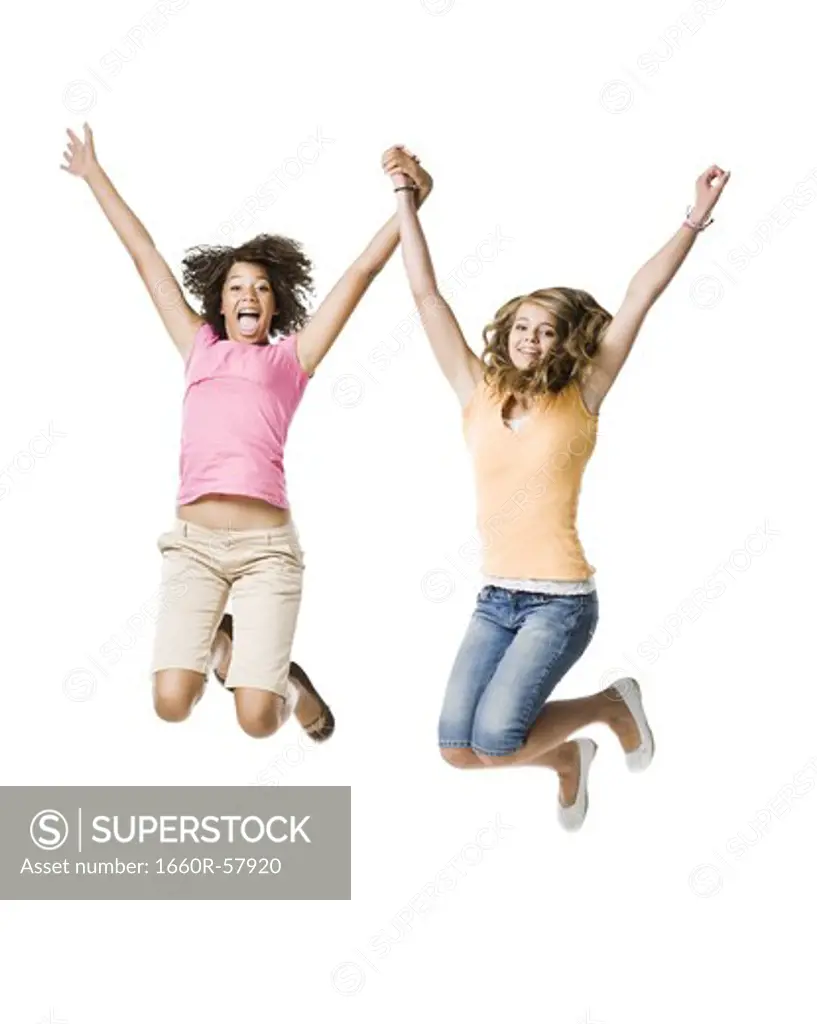 Two girls with braces holding hands and leaping