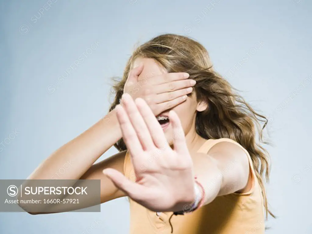 Girl covering eyes and holding out hand