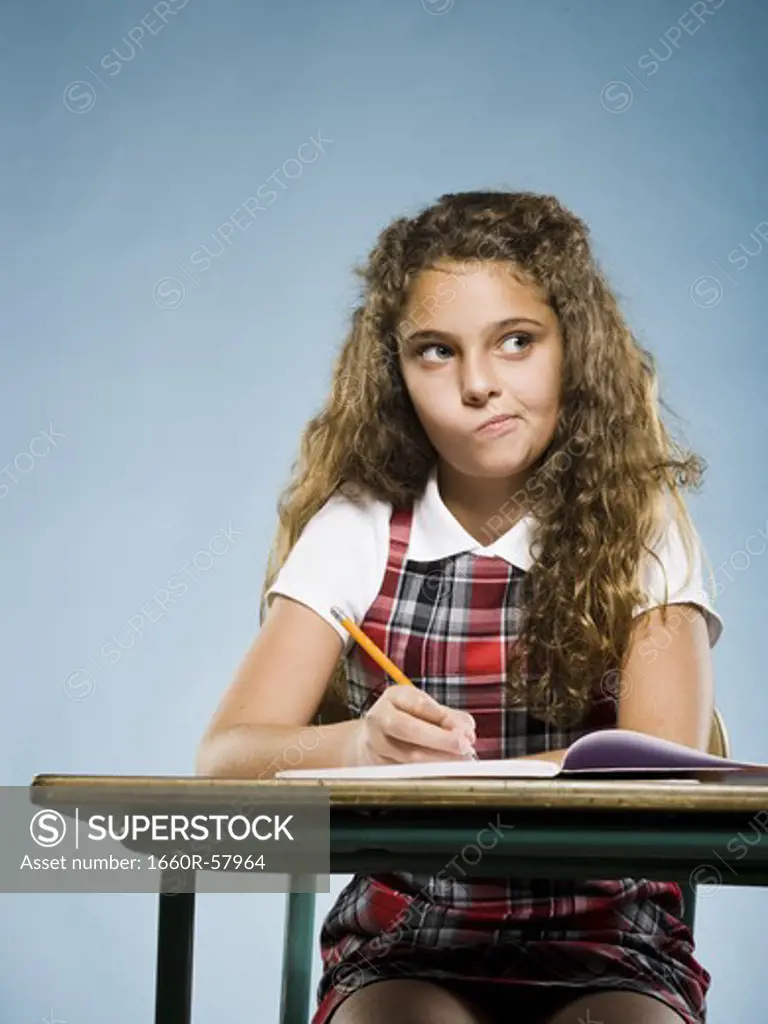 Girl sitting at desk with workbook concentrating