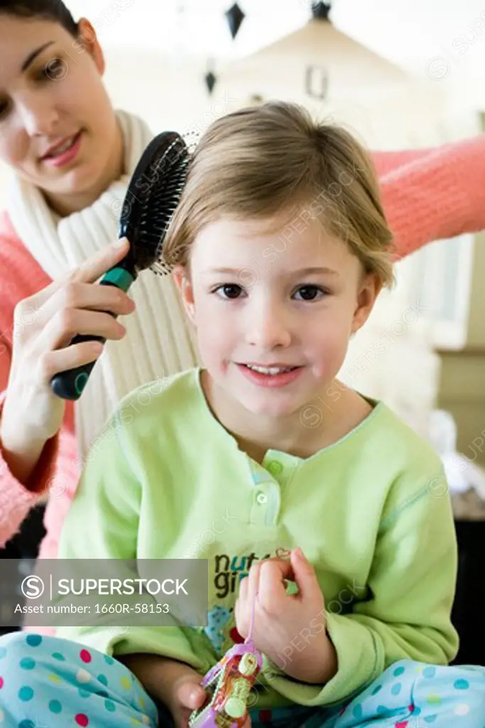 woman brushing a girl's hair