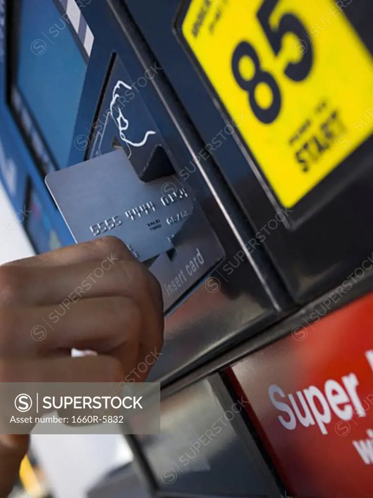Close-up of a person paying for gas with a credit card