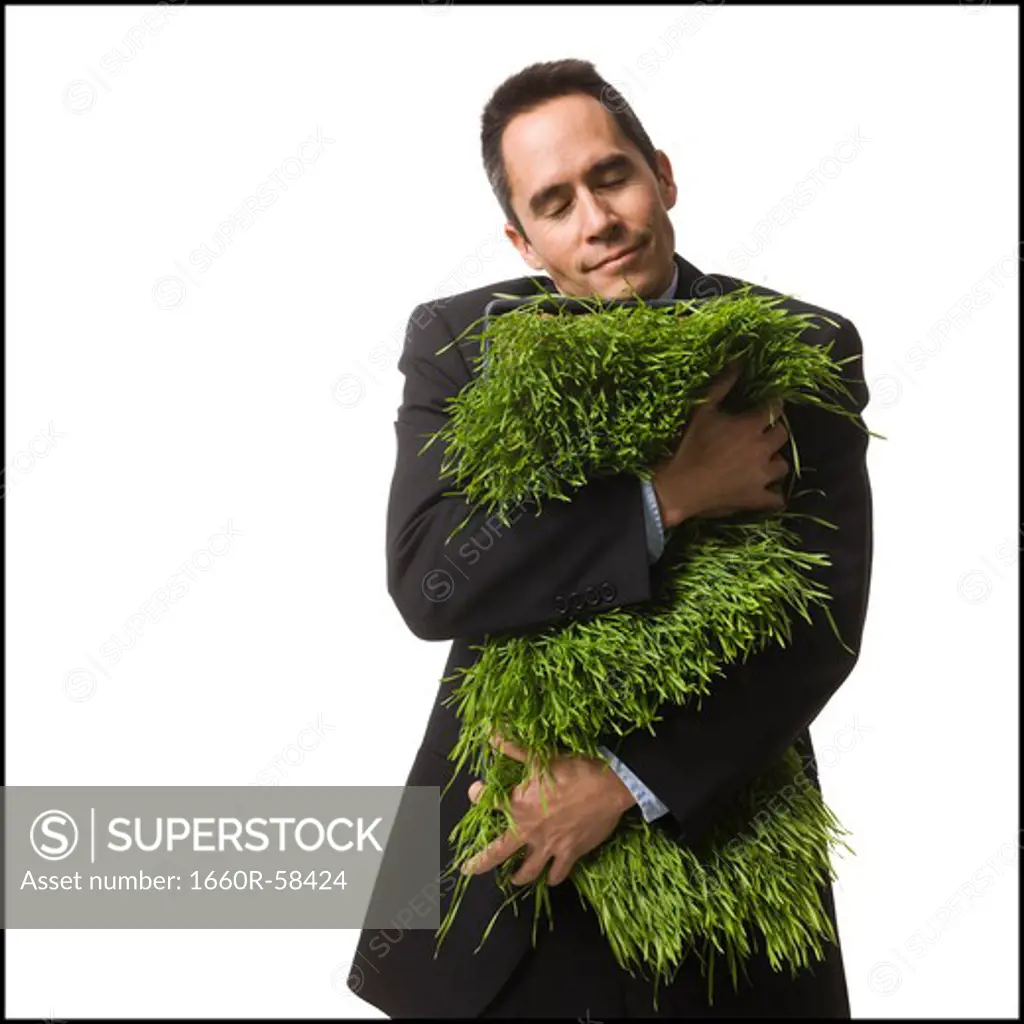 businessperson holding a patch of grass