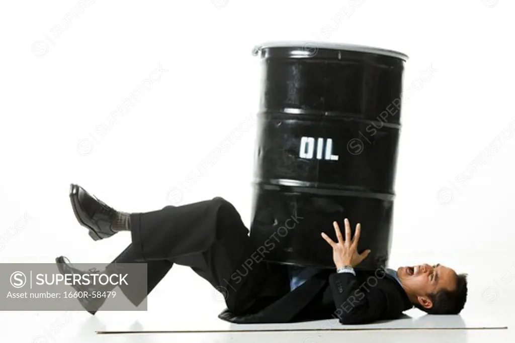 man being crushed by an oil barrel