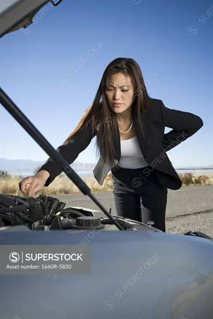 Woman repairing checking her car engine