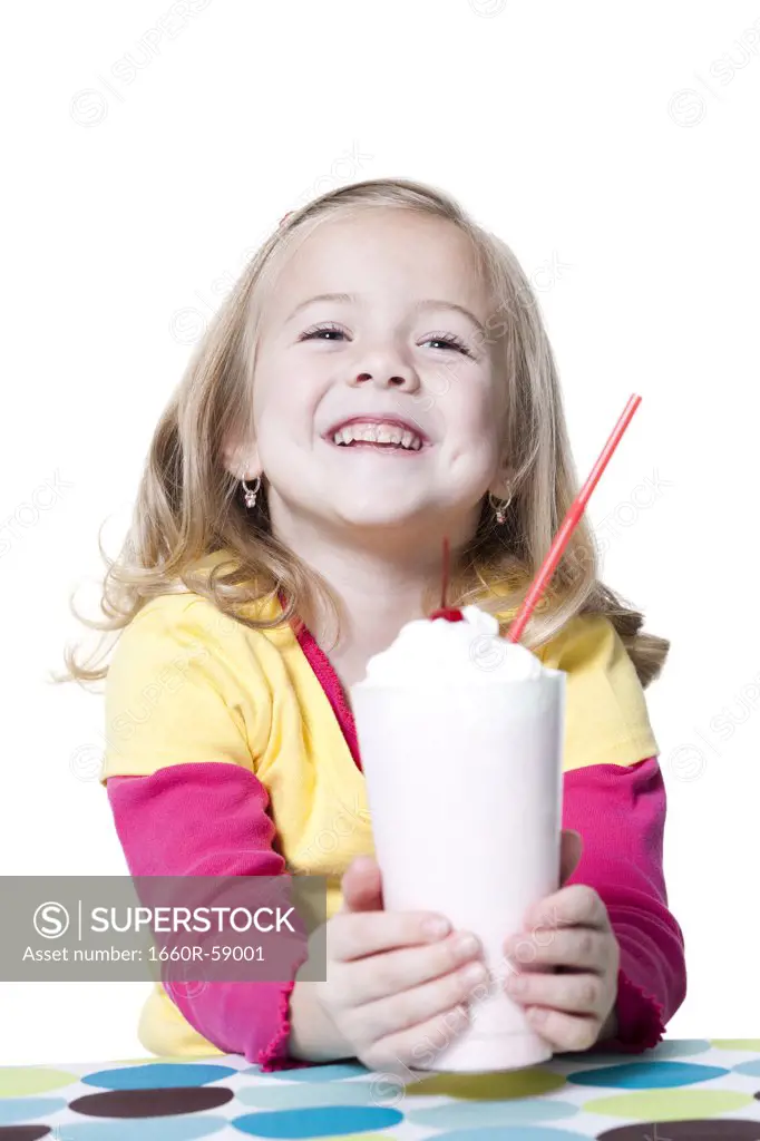 Girl holding milkshake and smiling