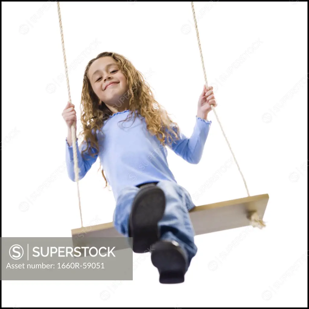 Young girl playing on a swing