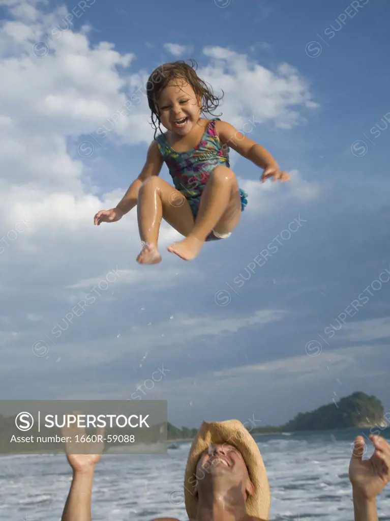 Father tossing his daughter in air