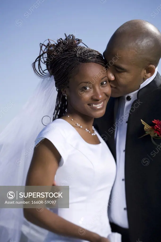Close-up of a groom kissing his bride