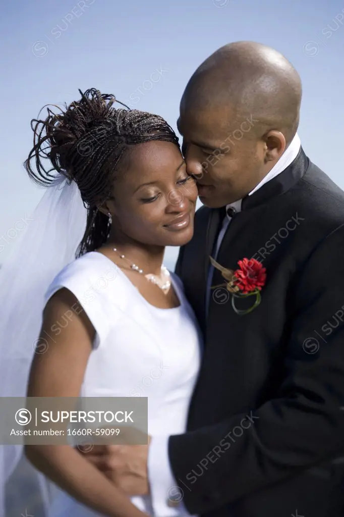 Close-up of a groom kissing his bride