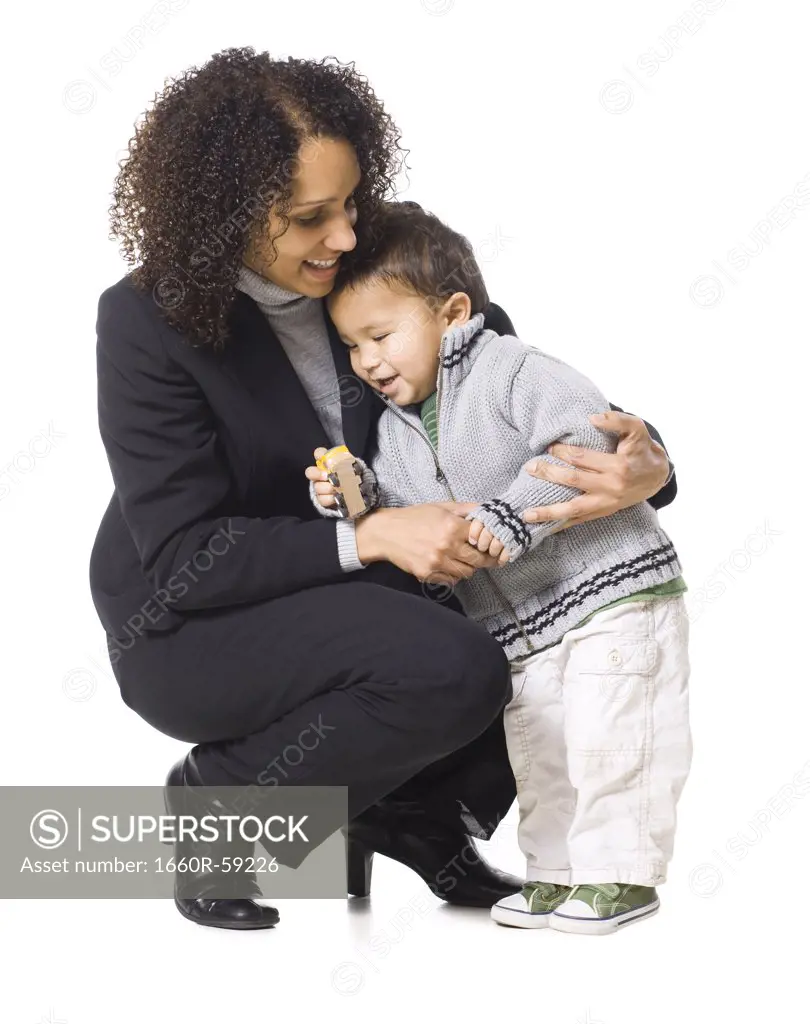 Mother embracing son (18-23 months), studio shot