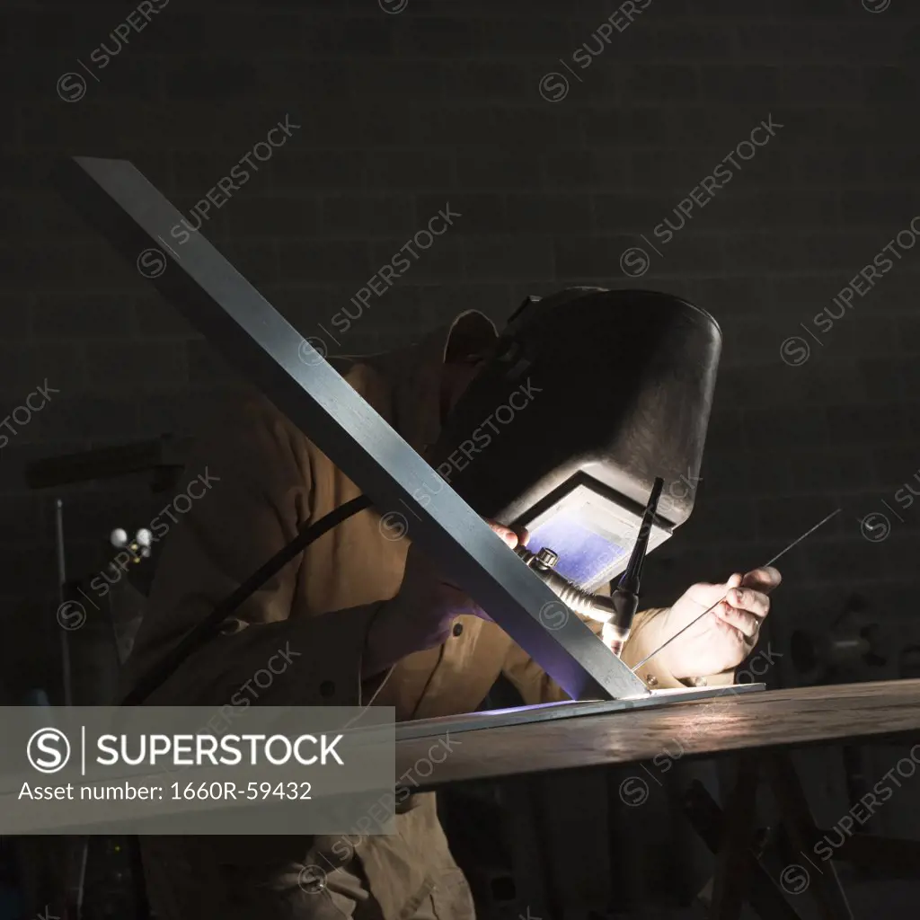 USA, Utah, Orem, man soldering metal in workshop