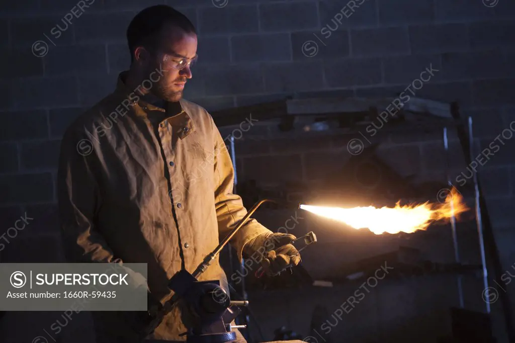 USA, Utah, Orem, male welder using blowtorch in workshop