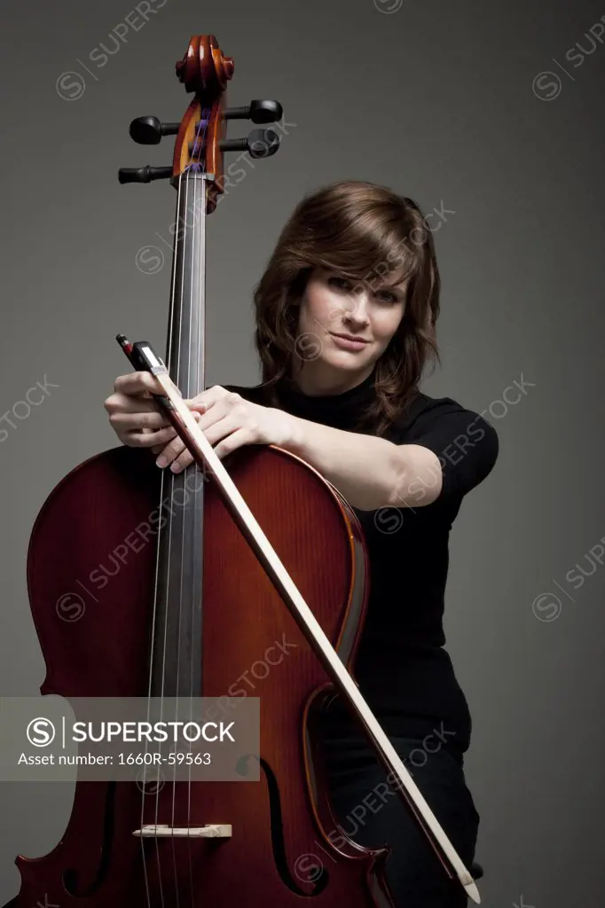 Studio portrait of young woman with cello
