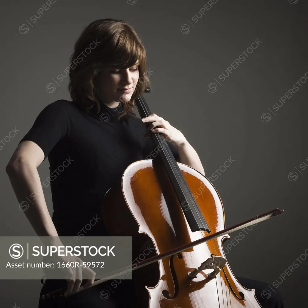 Young woman playing cello, studio shot