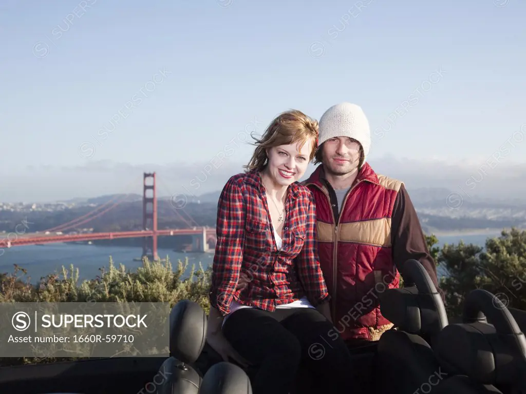 USA, California, San Francisco, young couple sitting, Golden Gate Bridge in background