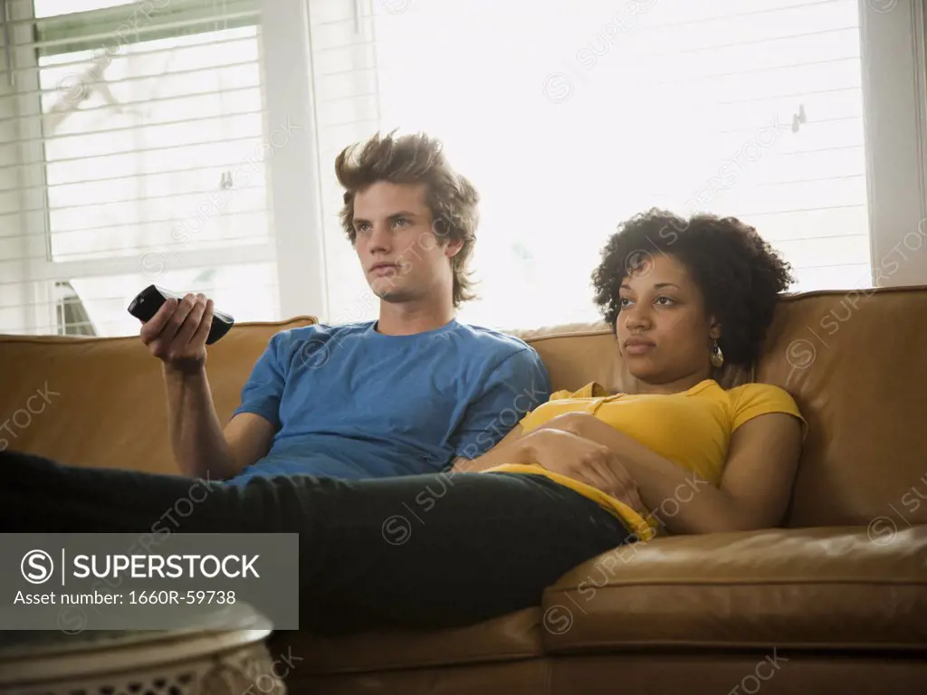 USA, Utah, Provo, couple sitting on sofa watching TV