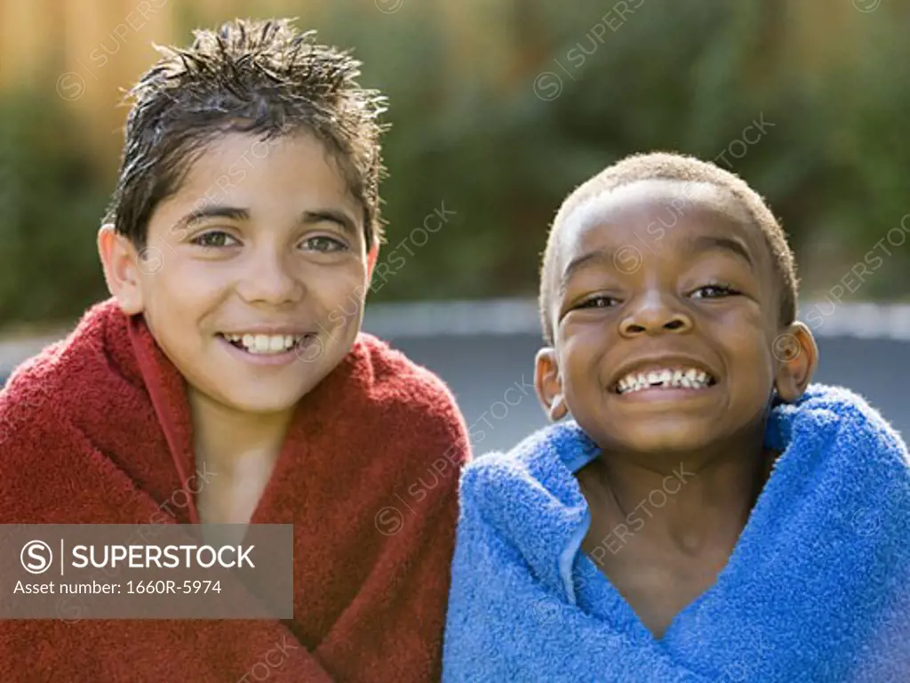 Close-up of two boys wrapped in towels