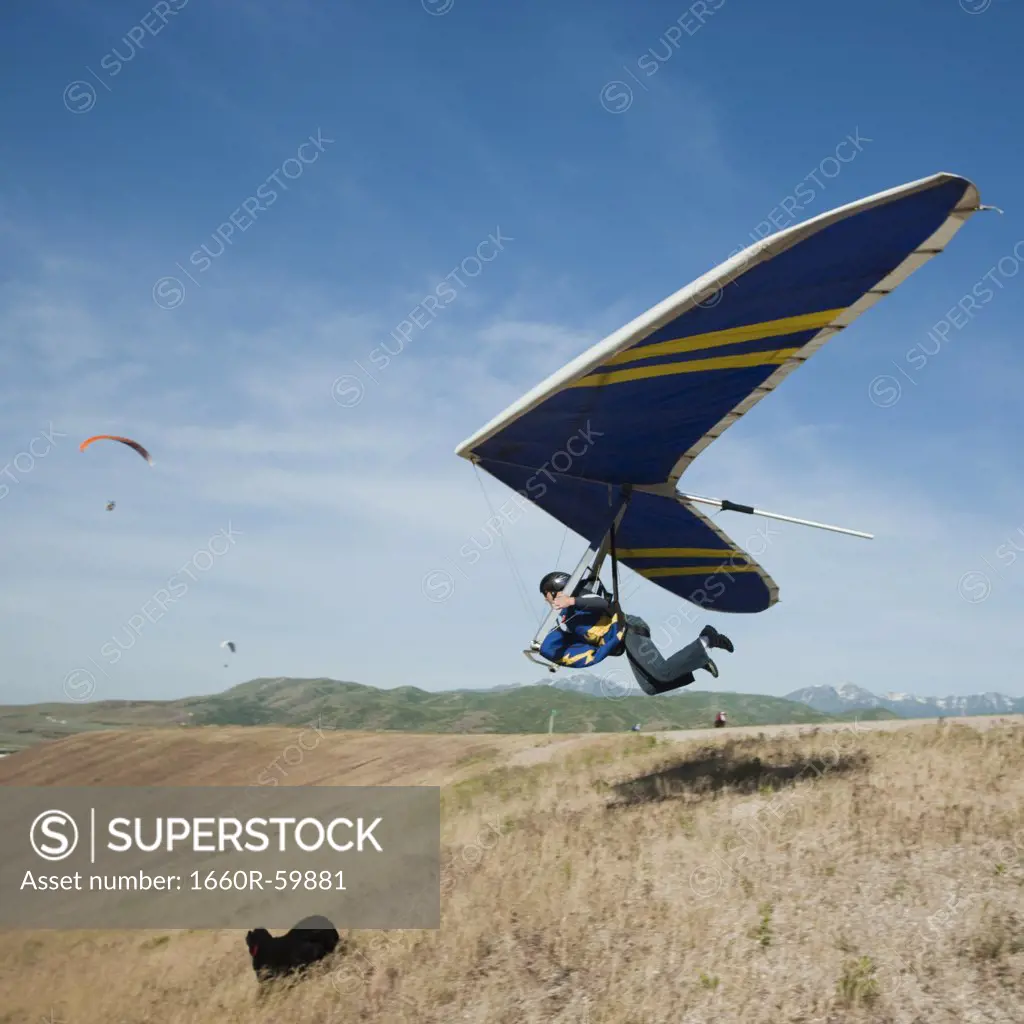 USA, Utah, Lehi, young man taking off with hang glider