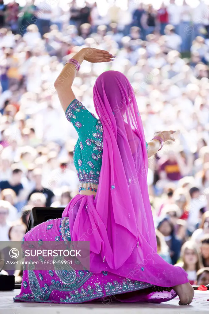 USA, Utah, Spanish Fork, rear view of mid adult dancer in traditional clothing performing on stage