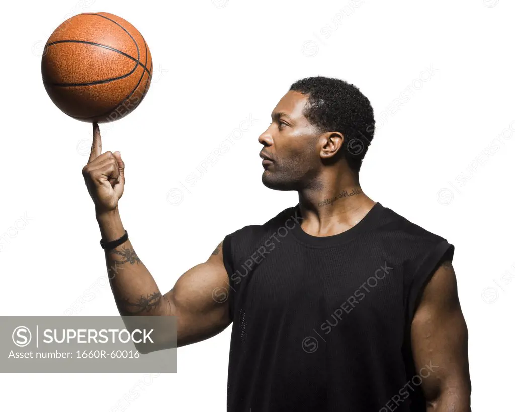 Mid adult man spinning basketball in air