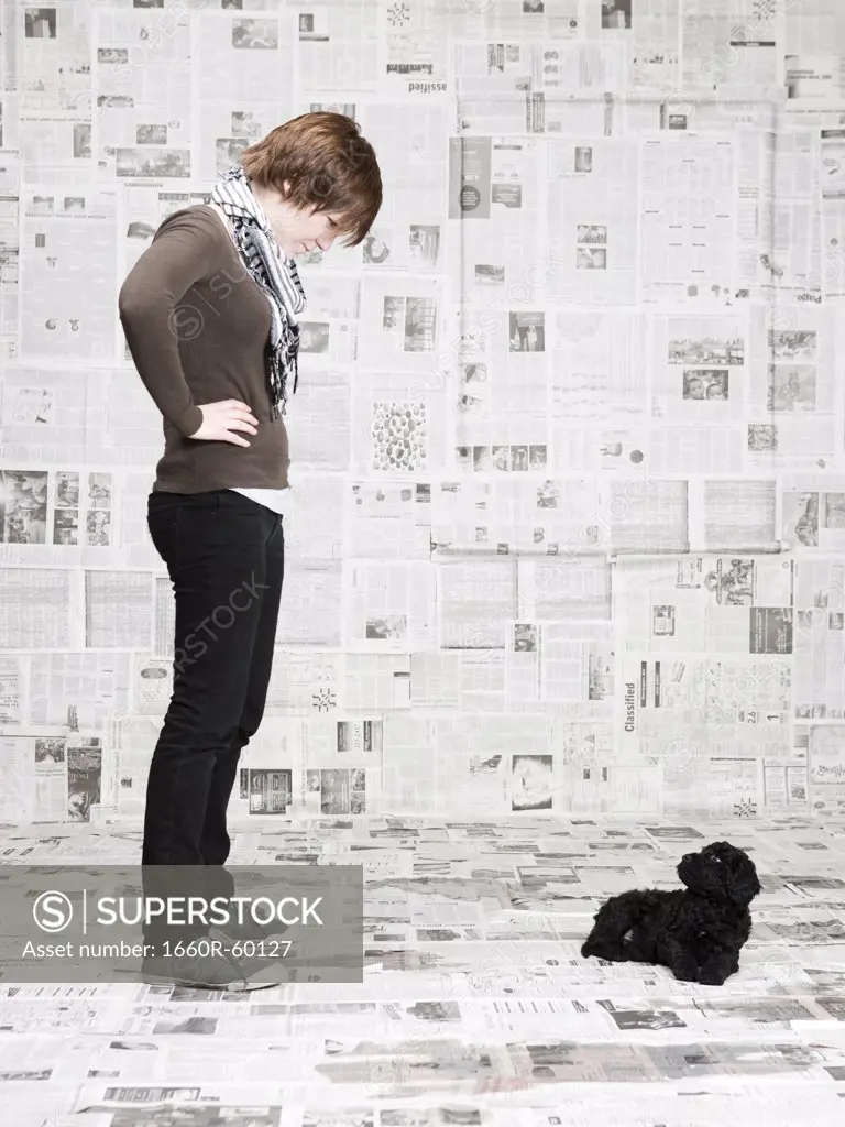 Studio shot of young woman scolding dog