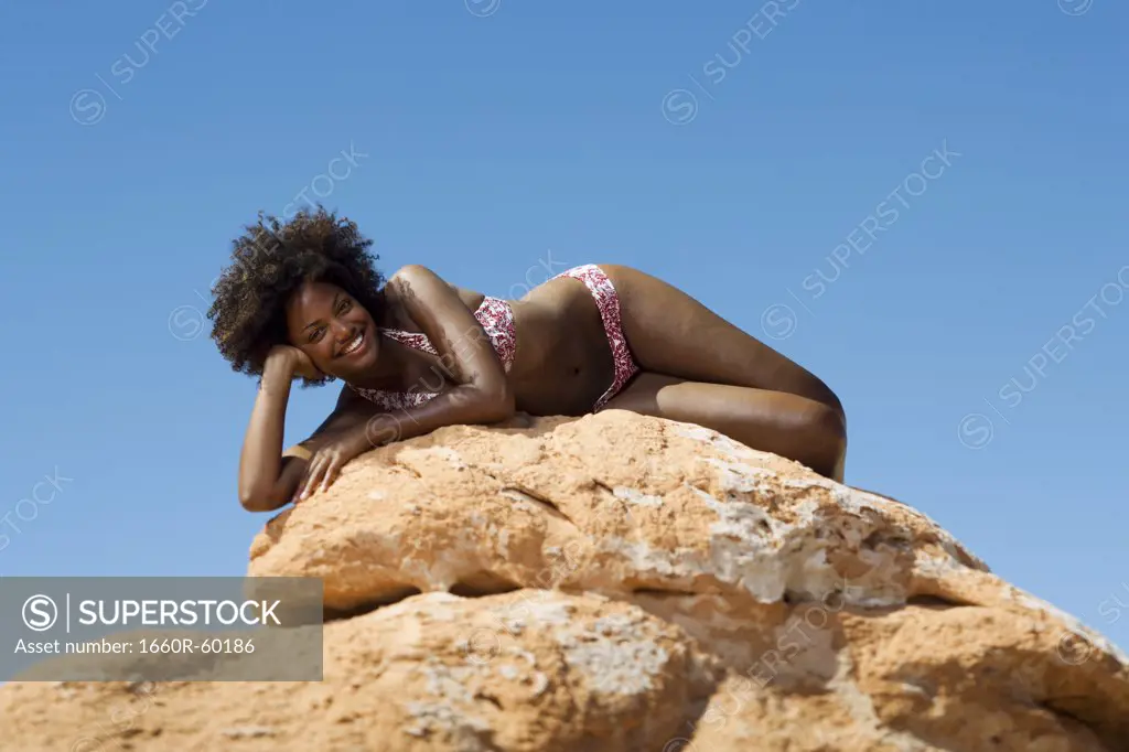 USA, Utah, Lake Powell, young woman in bikini lying on rocks
