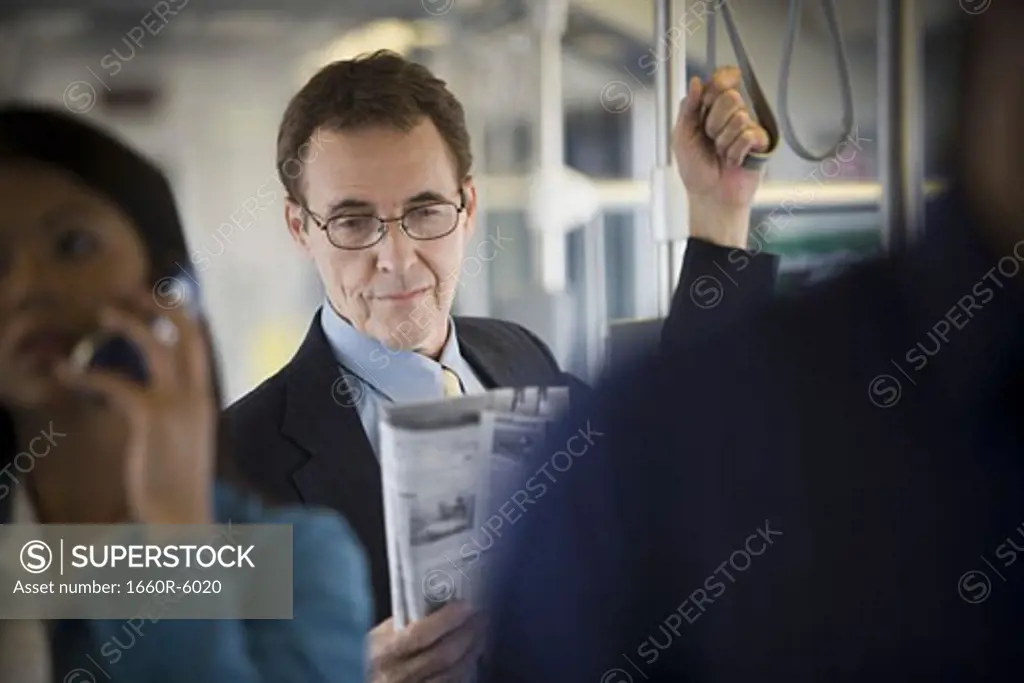 Mature man and a woman standing on a commuter train