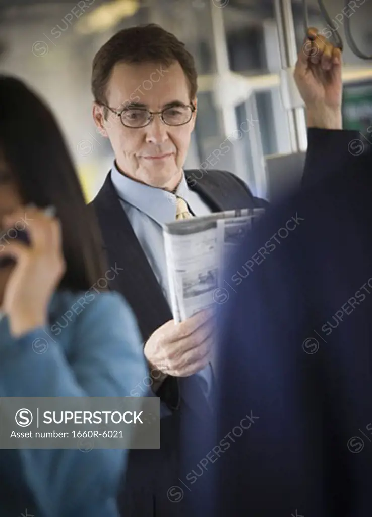 Businessman reading a newspaper on a commuter train