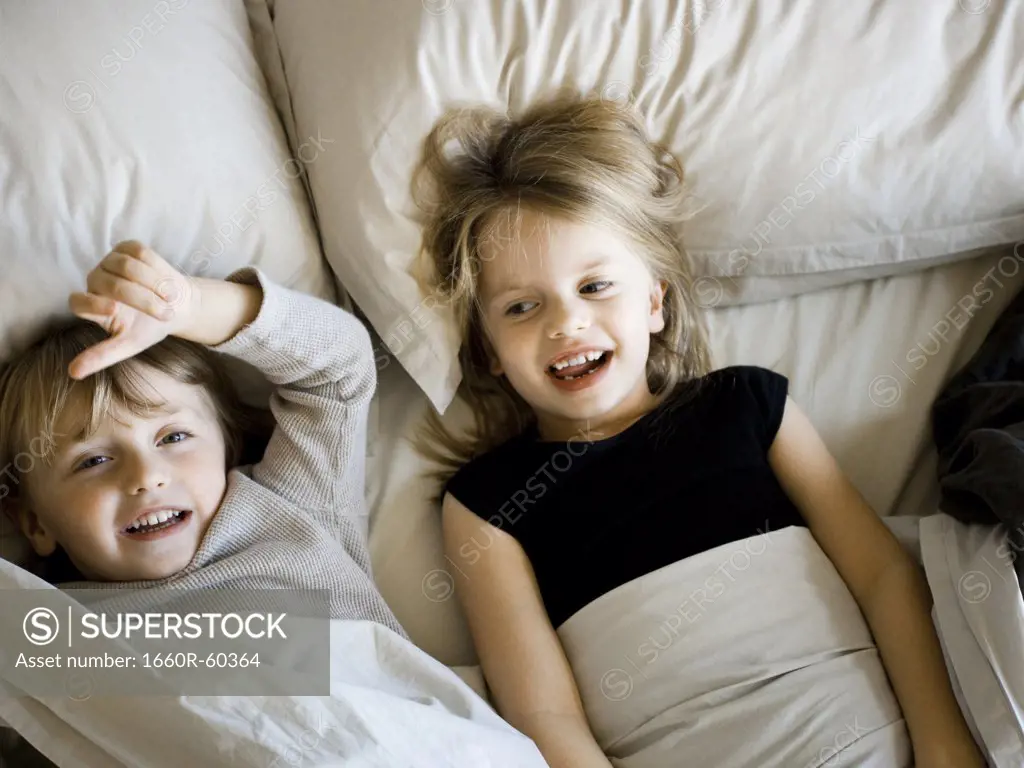 USA, Utah, Provo, Portrait of brother and sister (2-5) lying in bed